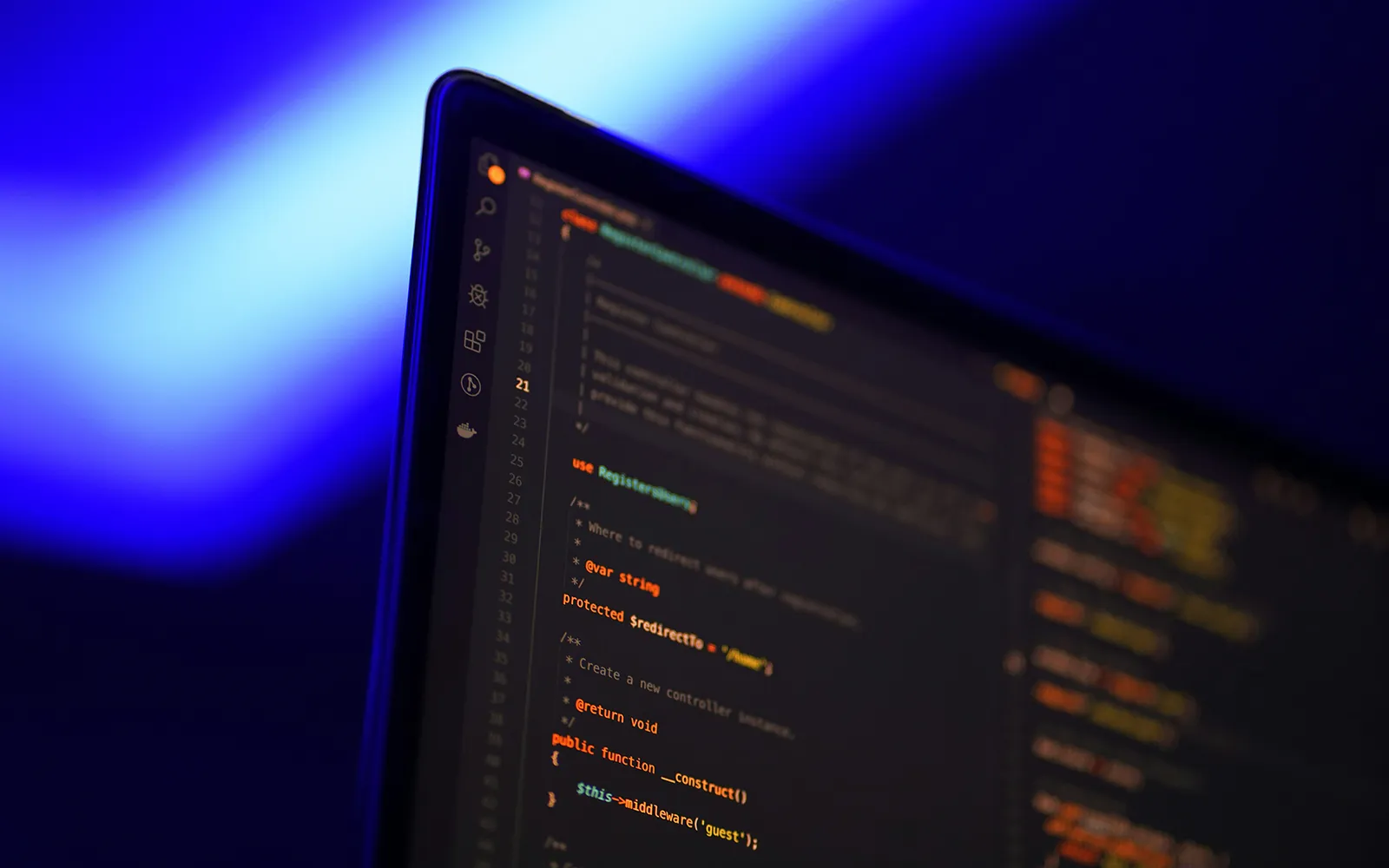 Laptop screen showing GitHub code in a dark room