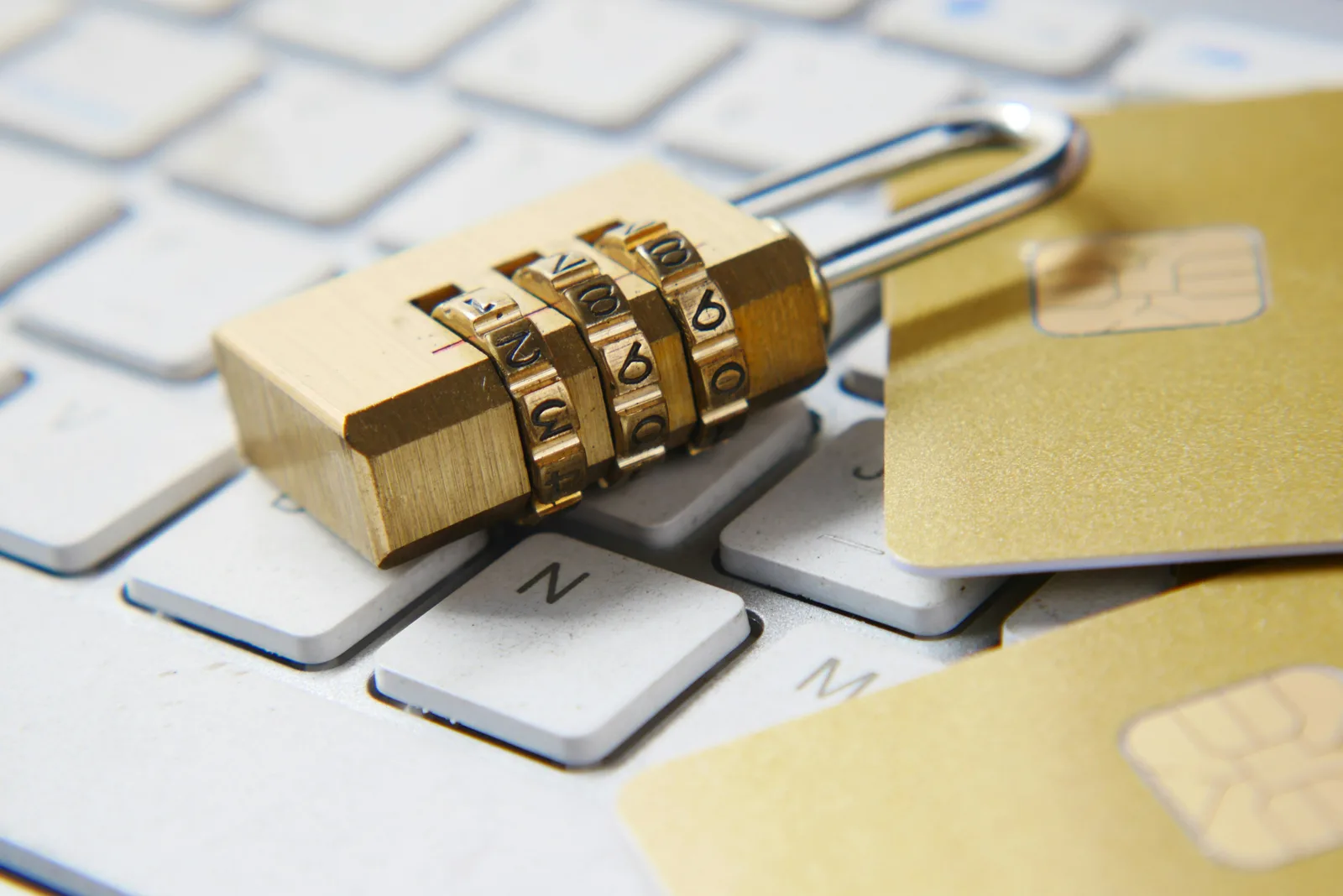 A padlock and credit cards resting on a keyboard