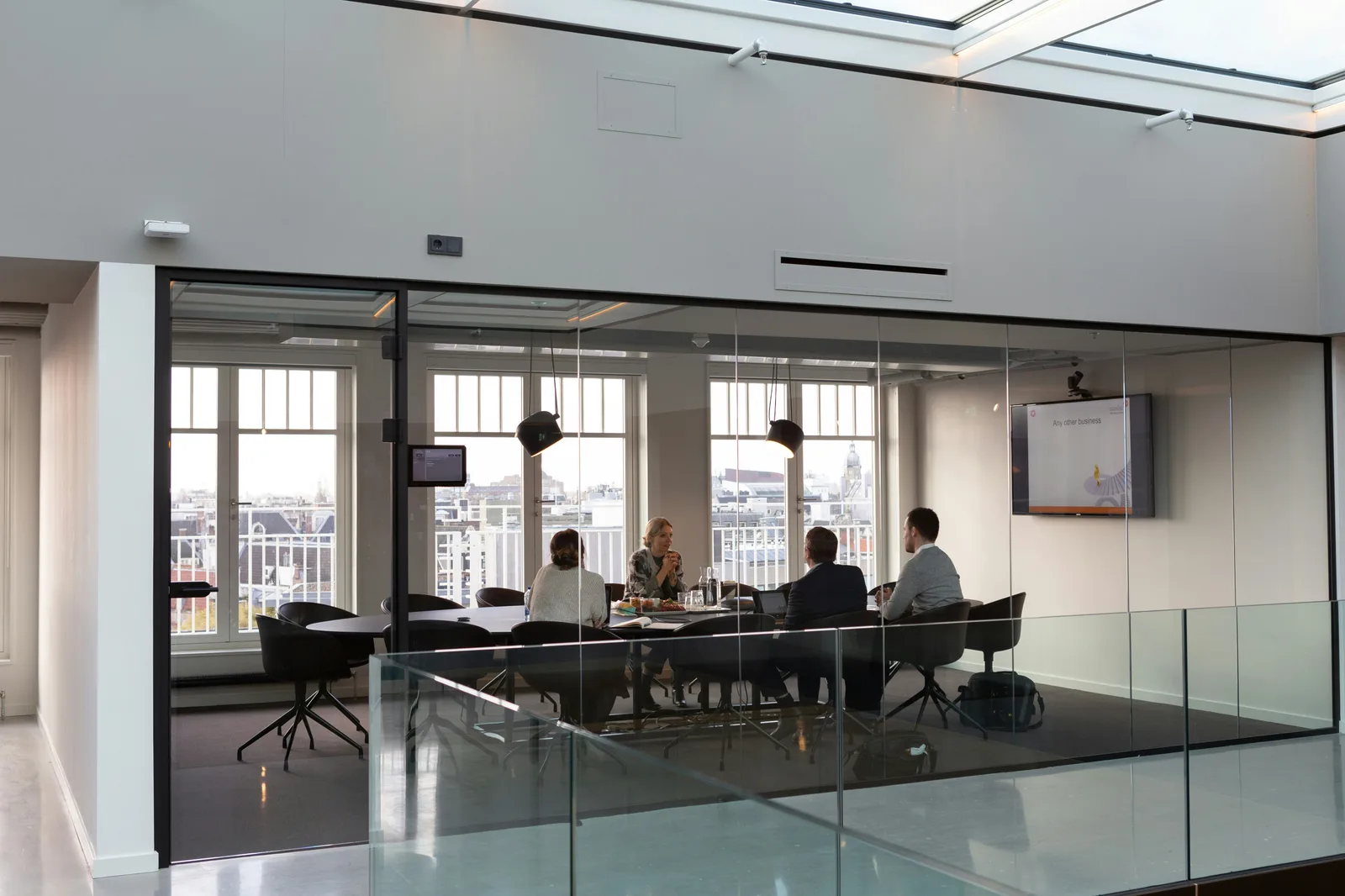 People in discussion in a glass-walled meeting room